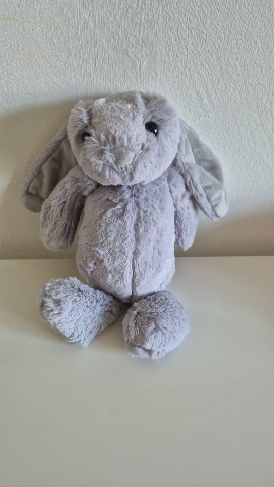 Pluche knuffelkonijn in lichtgrijze kleur met lange hangoren, glanzende zwarte ogen en een zachte vacht, zittend tegen een witte achtergrond.